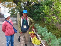 正門付近に並ぶ植物を説明する北居重信さん